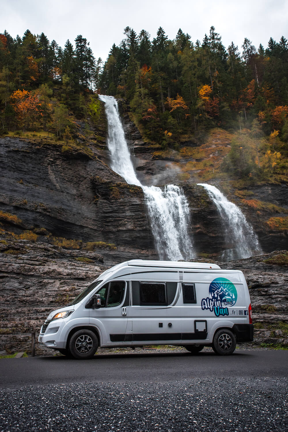 Van 'Le Baroudeur' stationné devant une cascade