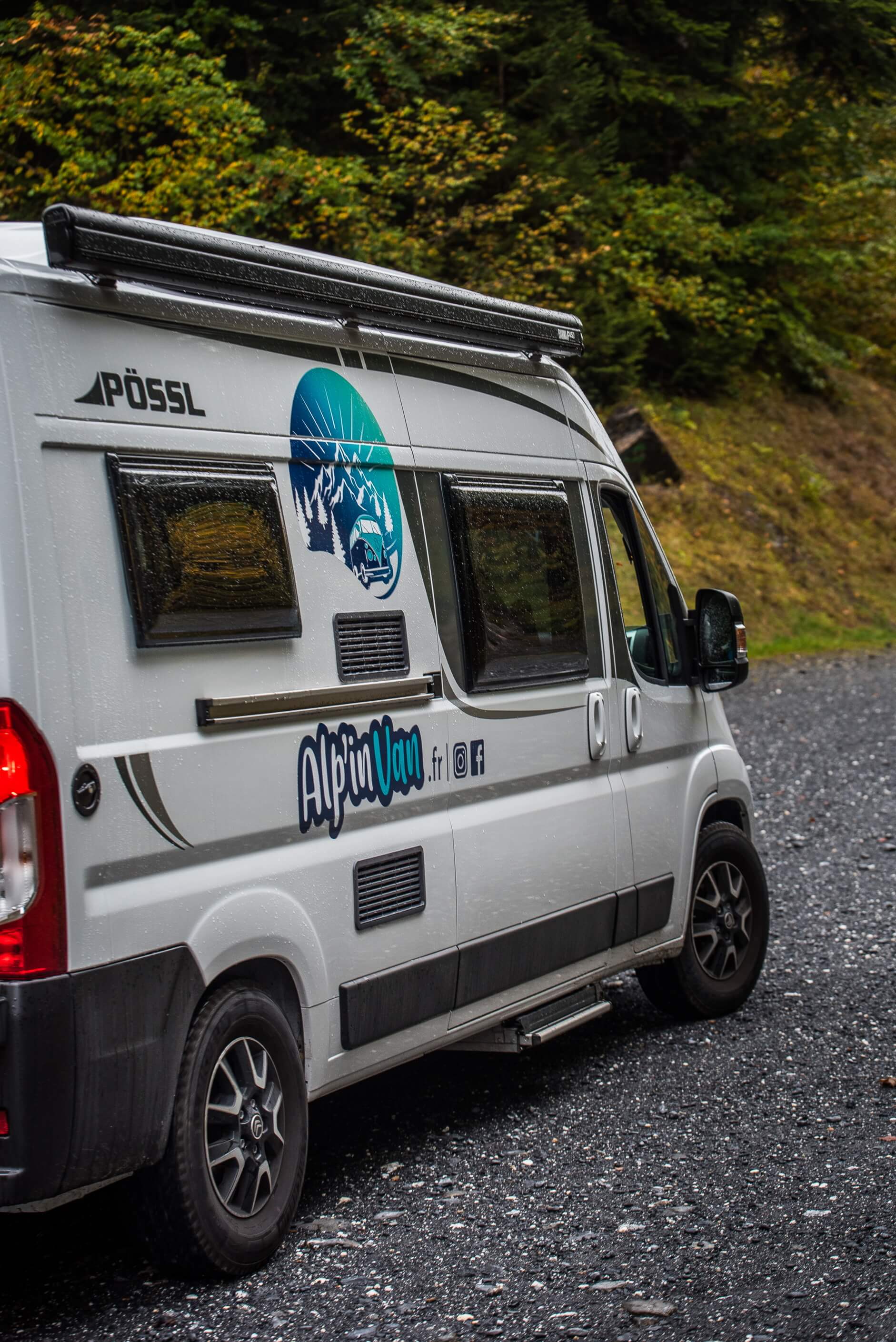 Van 'Le Baroudeur' sur un chemin en graviers dans une forêt