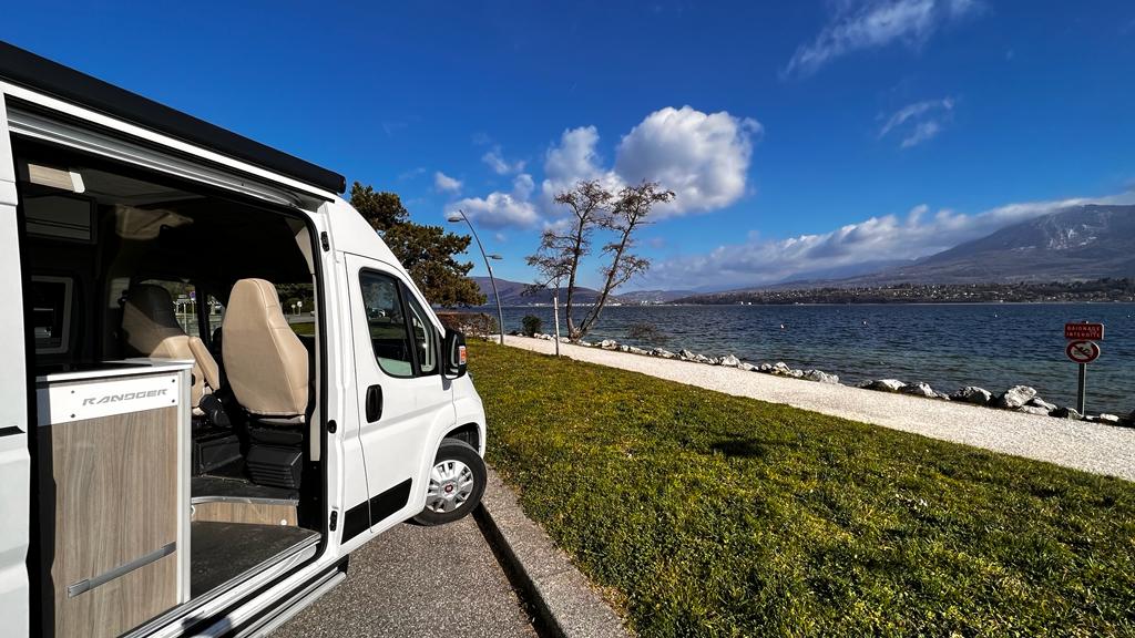 Van aménagé stationné devant un lac